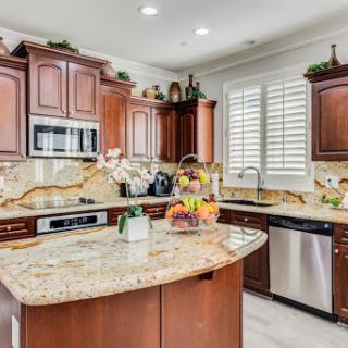 A beautifully designed modern kitchen featuring rich wood cabinetry, granite countertops, and ample natural light.