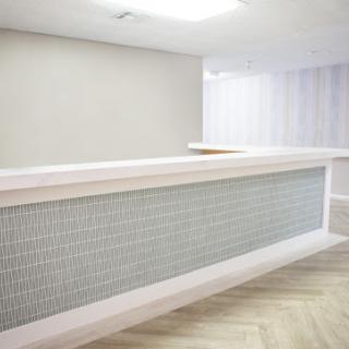 A sleek and modern reception desk in a minimalist office environment.