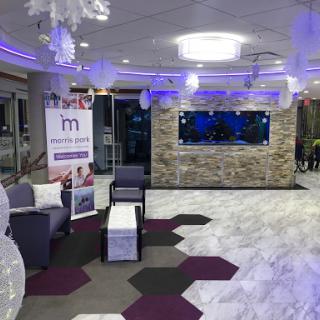 A modern lobby featuring a stylish seating area and an aquarium, illuminated with ambient lighting.