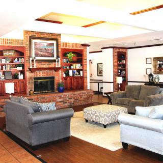 A cozy living room with a fireplace, sofas, and bookshelves.