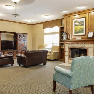 A cozy living room with a fireplace, sofas, and a television.