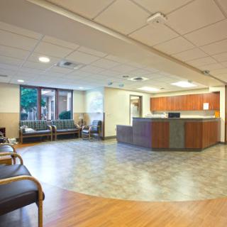 A spacious and modern hospital reception area with seating and a front desk.