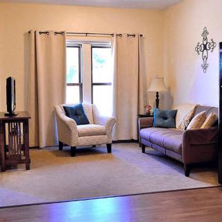 A cozy living room with a sofa, armchair, and decor.