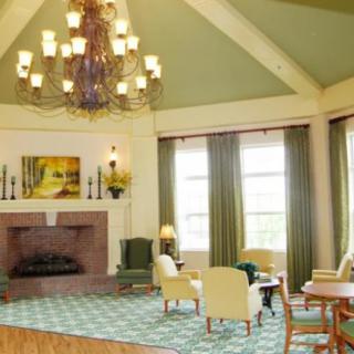A cozy living room with a large chandelier, fireplace, and comfortable seating.
