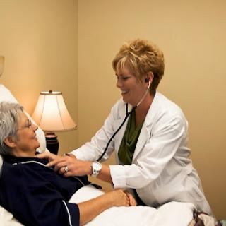 A healthcare professional conducting a check-up on an elderly patient in a clinical setting.