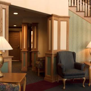A cozy lobby area featuring comfortable seating, elegant wooden details, and warm lighting.