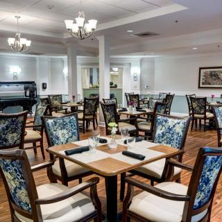 An elegant restaurant dining area featuring well-arranged tables and chairs with a classic decor.