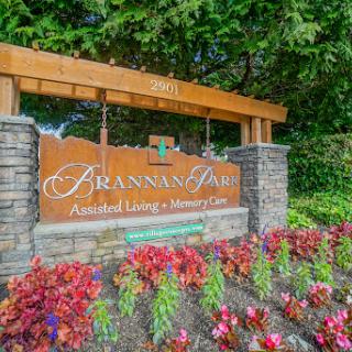 Entrance sign of a community offering assisted living and memory care services, surrounded by beautiful landscaping.