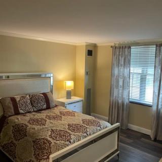 Cozy bedroom with a patterned bedspread and soft lighting.