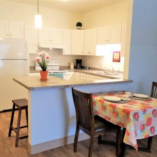 A cozy kitchen and dining area with a floral tablecloth and modern appliances.