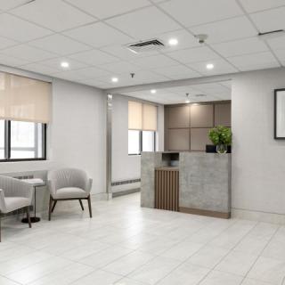 A modern and minimalist office reception area with seating and a front desk.