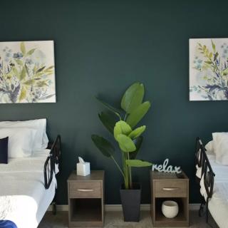 A cozy bedroom with twin beds, nightstands, and decorative wall art.