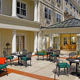 Outdoor patio area with tables and chairs in front of a building.
