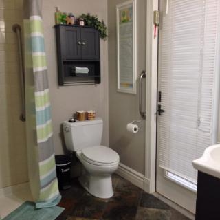 A well-organized bathroom with a shower curtain and shelving.