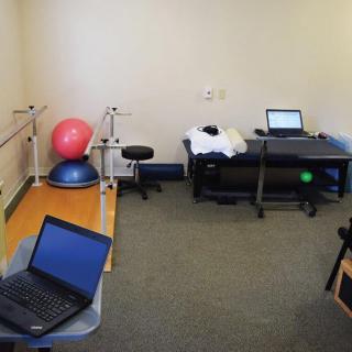 A physical therapy room equipped with exercise equipment and computers.