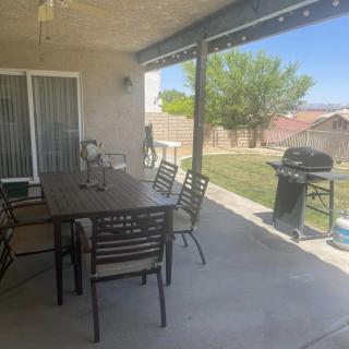 A cozy patio with a dining set and grill, perfect for outdoor gatherings.