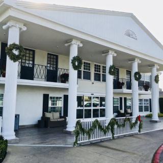 A colonial-style building adorned with holiday wreaths and decorations.