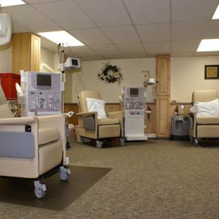 A medical treatment room with dialysis machines and comfortable chairs.