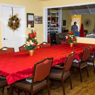 A festive dining room decorated with red tablecloths and floral arrangements, ready for a holiday gathering.