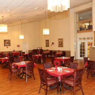 A cozy restaurant dining room with neatly arranged tables and warm lighting.