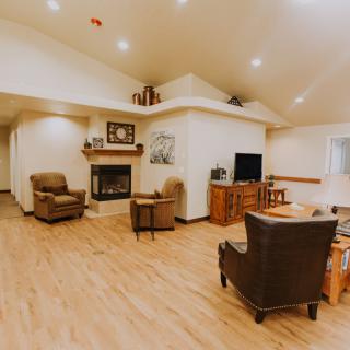 A cozy living room with comfortable seating, a fireplace, and a television.