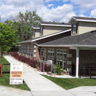A modern building featuring a 'Now Leasing' sign, surrounded by lush green landscaping and blue skies.