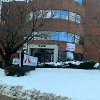 A brick office building partially covered in snow during winter.