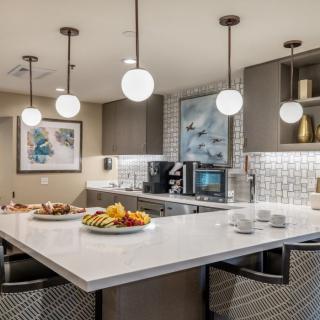 A modern kitchen with an island counter, pendant lights, and stylish decor.