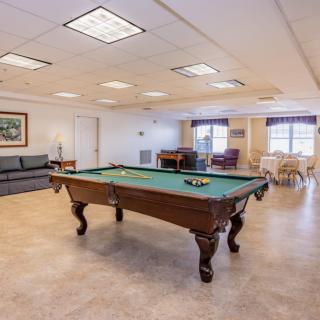 A spacious game room featuring a pool table and seating area.