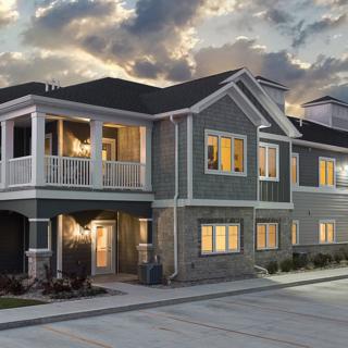A modern residential house with illuminated windows at twilight.