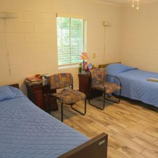 A cozy bedroom with two twin beds and blue bed covers.