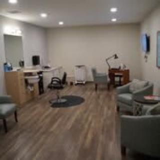 A modern office space with desks, chairs, and a lamp.