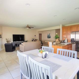 A spacious open floor plan featuring a modern living room, dining area, and kitchen.