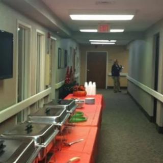 A buffet setup in a hallway with tables and catering equipment.