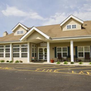 A residential building with a peaked roof and multiple windows.