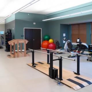 A well-equipped rehabilitation gym with exercise equipment and therapy tools.