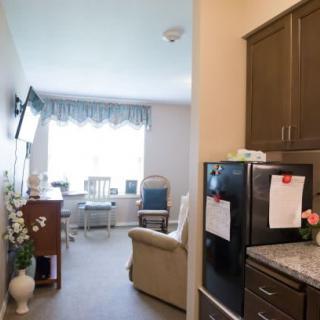 A cozy apartment with a small kitchen area and a bright living room.