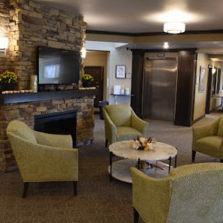 A cozy and inviting lobby area featuring comfortable seating, a stone fireplace, and modern decor.