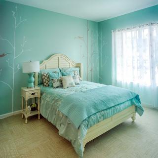 A cozy turquoise-themed bedroom with a neatly made bed and natural light filtering through the window.