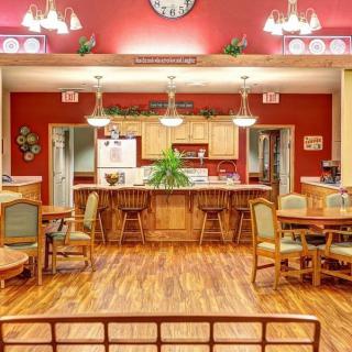 A spacious kitchen and dining area with wooden floors, ample seating, and warm lighting.