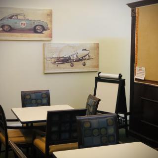 A cozy cafe interior with vintage artwork and neatly arranged seating.