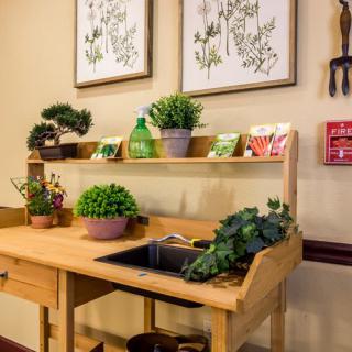 A cozy indoor gardening workstation with potted plants and seed packets displayed on a wooden table.