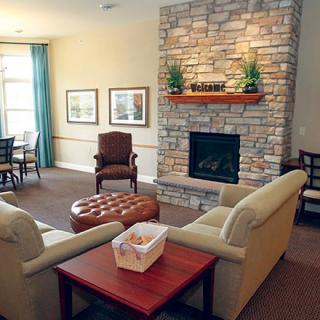 A cozy living room featuring a stone fireplace, comfortable seating, and tasteful decor.