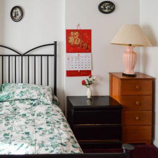 A cozy bedroom with a bed, nightstand, and decorative elements.