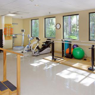 A bright and spacious fitness area equipped for rehabilitation and exercise with various workout tools.