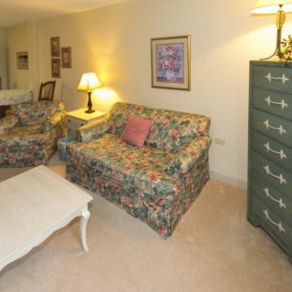 A cozy living room with floral patterned furniture and soft lighting.