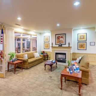 A cozy living room with sofas, a fireplace, artwork, and elegant decor.