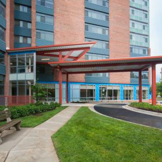 Modern apartment building entrance with landscaped surroundings.