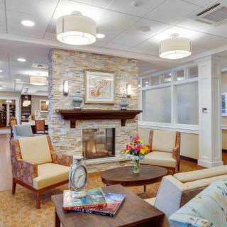 A cozy living room interior featuring a stone fireplace and comfortable seating.