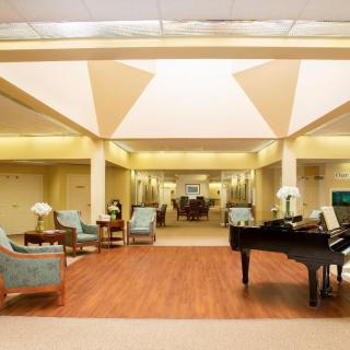A spacious and elegantly designed lobby featuring a grand piano and comfortable seating.